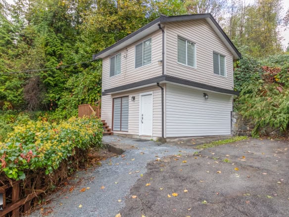 2. Modern two-storey house with white siding and large windows, surrounded by lush greenery and mature trees, ideal for buyers seeking a peaceful residential property in Ontario.