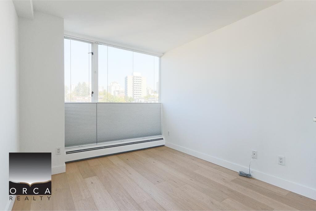 Bright empty apartment room with large windows and city views - ideal for Vancouver real estate listings and property marketing.