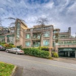 Modern Vancouver condo building with landscaped gardens and underground parking, offering prime real estate options in the heart of the city.