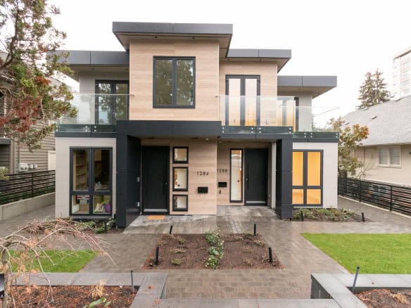 Modern contemporary townhouse with sleek black and natural wood exterior, large windows, and landscaped front yard, showcasing upscale real estate in Vancouver, British Columbia.