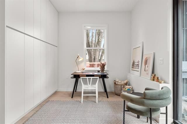 Modern minimalist home office with white walls, desk, comfortable chair, and natural light in Vancouver, BC, ideal for real estate photography and property staging.