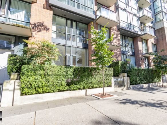 Modern Vancouver apartment building exterior with lush landscaping, glass balconies, and brick accents. Perfect for real estate investment and rental opportunities in downtown Vancouver.
