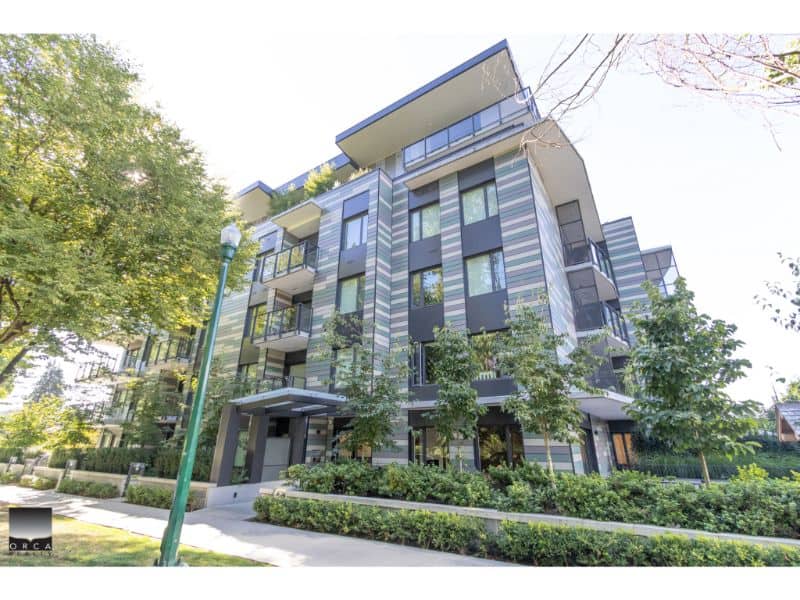 Luxury modern condominium building in Vancouver with stylish architecture, green landscaping, and spacious balconies for urban living.