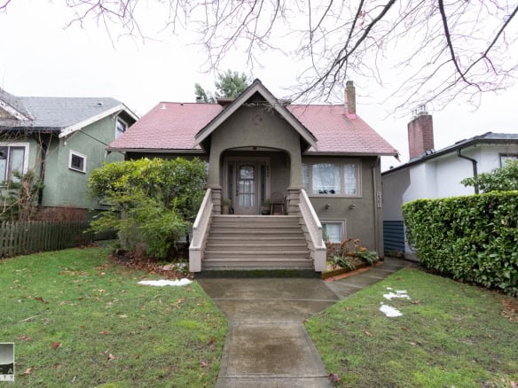 Charming single-family home in Vancouver with a welcoming front porch, lush landscaping, and classic architecture, perfect for families and real estate investment in the Lower Mainland.