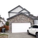 Modern house with stone and black-and-white exterior design, feature for sale or rent in BC, Canada.