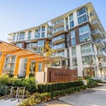 Modern waterfront condominium building with glass balconies and contemporary architecture in Vancouver, BC. Beautiful landscaped exterior with wooden pergola and clear blue sky.