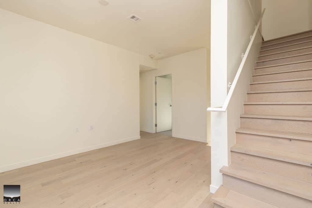 Bright and airy interior space with light wood flooring and staircase, perfect for Vancouver homebuyers seeking modern real estate options in British Columbia.