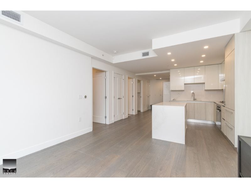 Bright modern open-concept kitchen with white cabinets and island, ideal for Vancouver real estate listings. Perfect for showcasing contemporary condos or apartments in the Vancouver area.