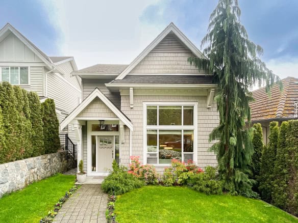 Beautiful Vancouver home with lush front yard, manicured lawn, and thriving greenery, showcasing prime real estate in the Pacific Northwest.