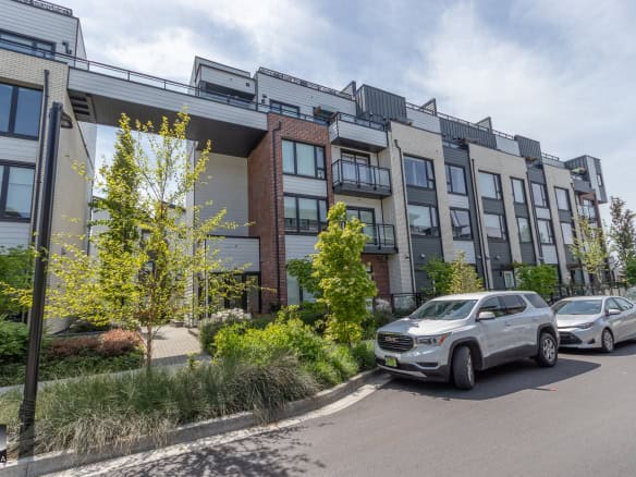 Modern multi-family residential apartment building with contemporary architecture and green landscaping in Vancouver, showcasing urban living in BC.