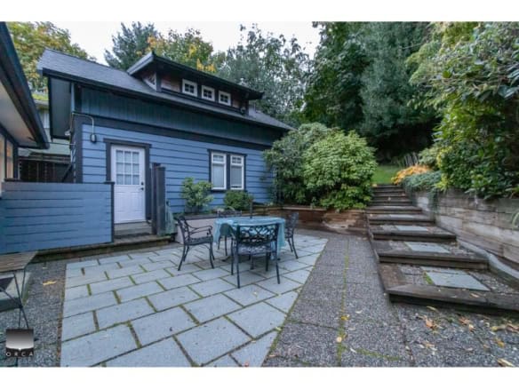 Cozy backyard patio with outdoor dining area and surrounding greenery at a residential property in Victoria, BC.