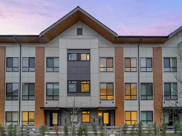 Contemporary multi-family residential building exterior in Vancouver at dusk, showcasing modern architecture and large windows, ideal for real estate investment and property sales in BC.