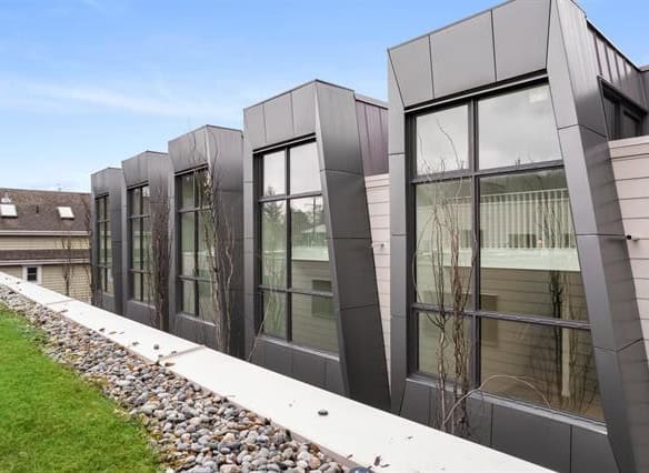 Modern commercial building with unique angular black metal and glass window design showcasing contemporary architecture in Victoria, BC.