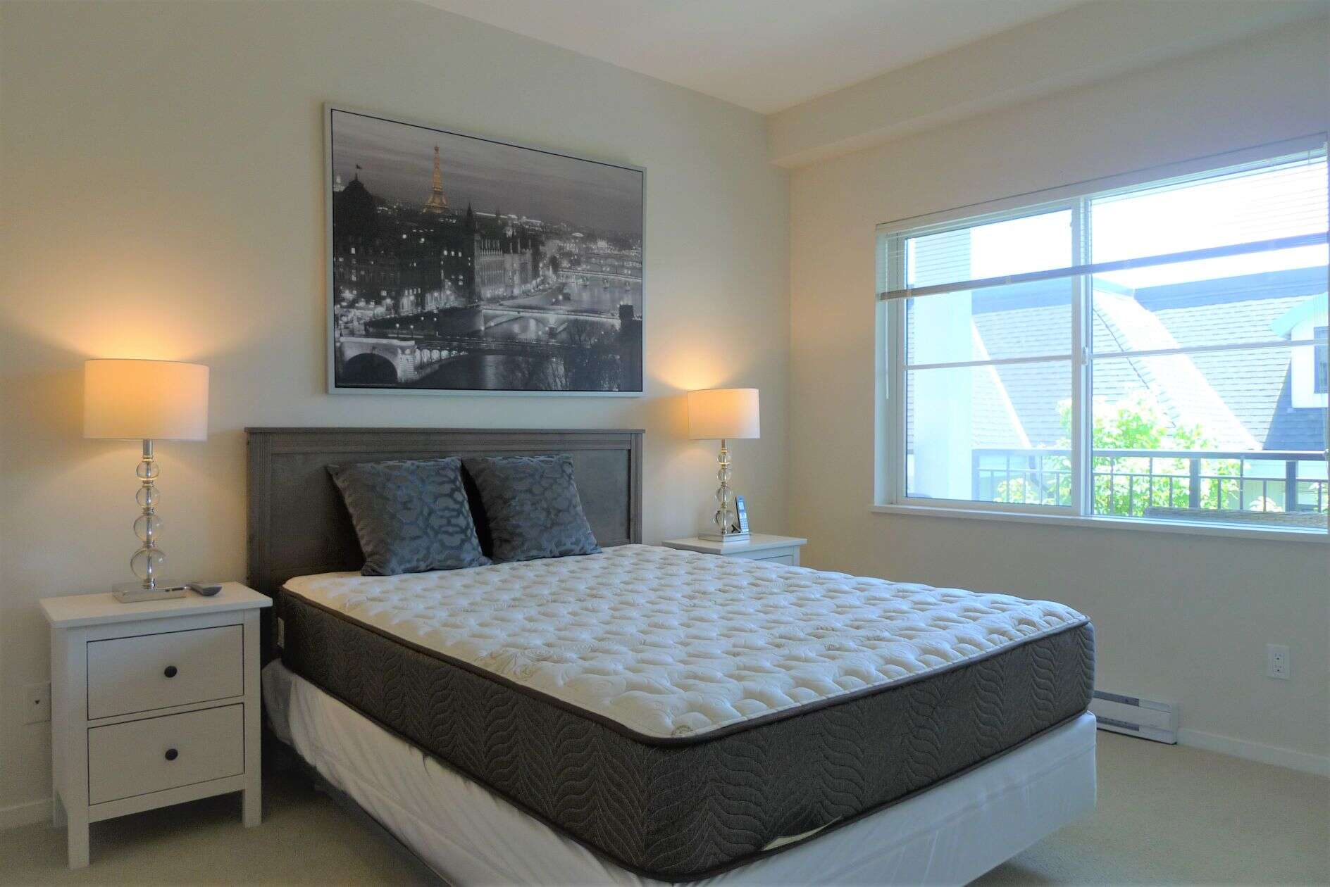 Modern bedroom with large window, neutral decor, and contemporary furnishings - perfect for Vancouver real estate listings.