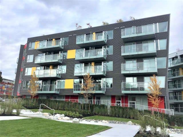 Modern multi-unit residential building with glass balconies and contemporary design in Vancouver, BC.