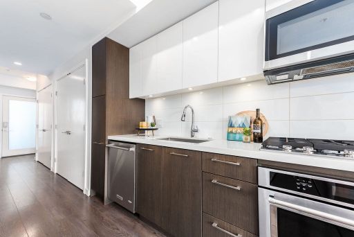 Contemporary modern kitchen with white upper cabinets, dark lower cabinets, stainless steel appliances, and a sleek design, perfect for upgrade and real estate listings.