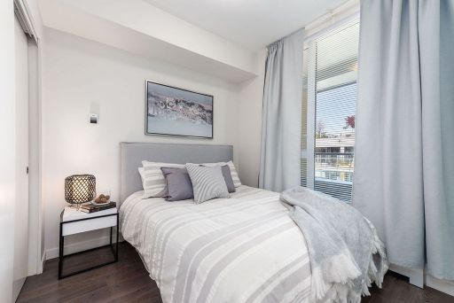 Modern bedroom with large windows and soft natural lighting, featuring stylish decor and comfortable bedding, ideal for Vancouver real estate listings.