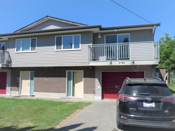 Spacious duplex home with modern design, brick and siding exterior, balconies, attached garage, and landscaped yard in a friendly neighbourhood.