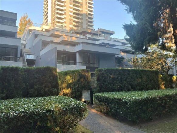 Modern Vancouver apartment building with contemporary architecture, lush landscaping, and ample outdoor greenery, ideal for luxury real estate investments and residential living in BC.