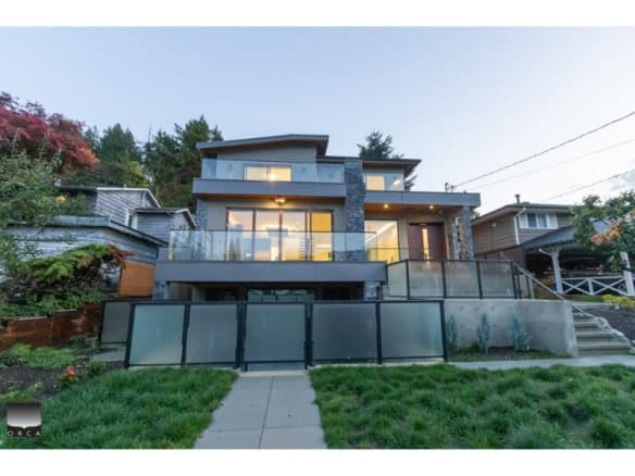 Modern luxury waterfront home with expansive terraces and glass railings, located in Vancouver's desirable neighbourhood, offered by Orca Realty Inc.