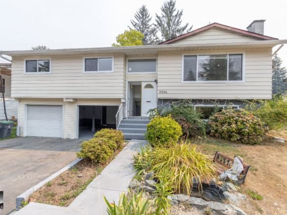 Modern suburban home with landscaped front yard, single-car garage, and mature trees, ideal for real estate listings and property sales in Vancouver.