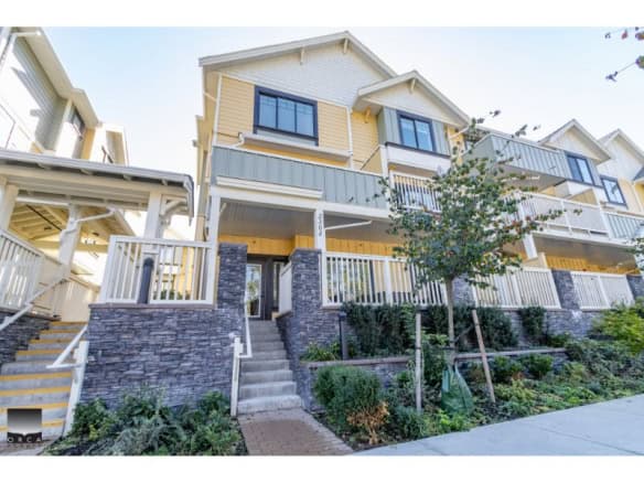 Contemporary multi-level townhouse with modern exterior, white railings, and landscaped front yard, ideal for homebuyers seeking stylish downtown Vancouver real estate.