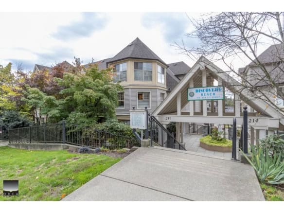 Charming residential building at Discovery Reach, Vancouver, with manicured landscaping and accessible entrance. Perfect for family living or investment in a scenic, vibrant neighbourhood.