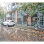 Modern urban apartment building on a rainy day in Vancouver, showcasing contemporary exterior design with large windows, brick accents, and a landscaped entrance, perfect for Vancouver real estate investing.