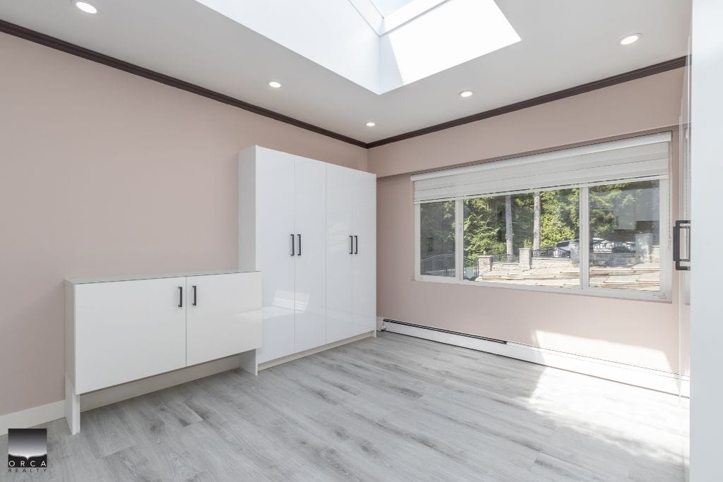 Bright modern interior with large window, skylight, and neutral decor, perfect for Vancouver home buyers seeking stylish real estate options.