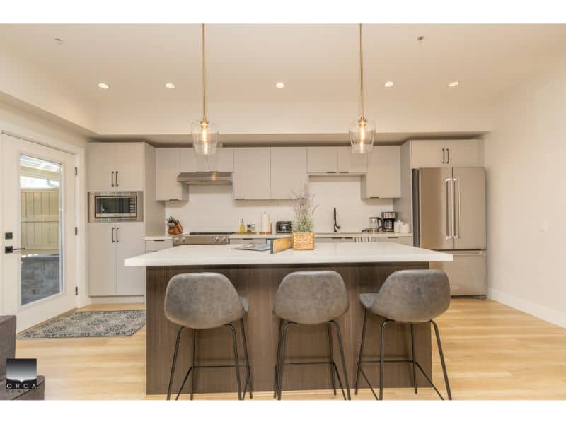 Modern kitchen with white cabinetry and stainless steel appliances by Orca Realty Inc. in a Vancouver-area home. Perfect for buyers seeking contemporary Vancouver real estate options.