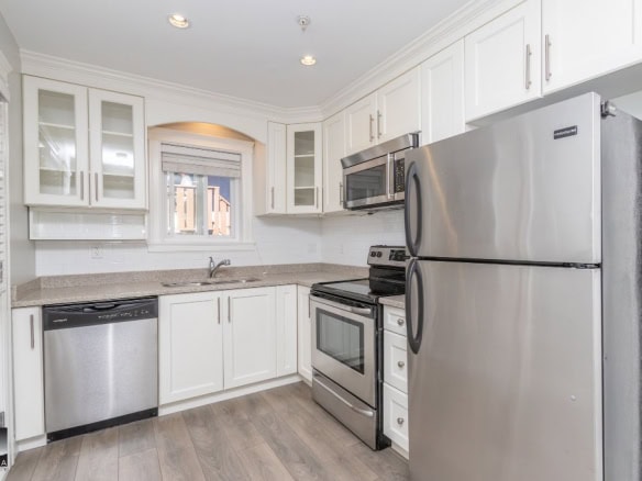 Contemporary white kitchen with stainless steel appliances, granite countertops, and modern cabinetry, perfect for Vancouver Island real estate buyers.
