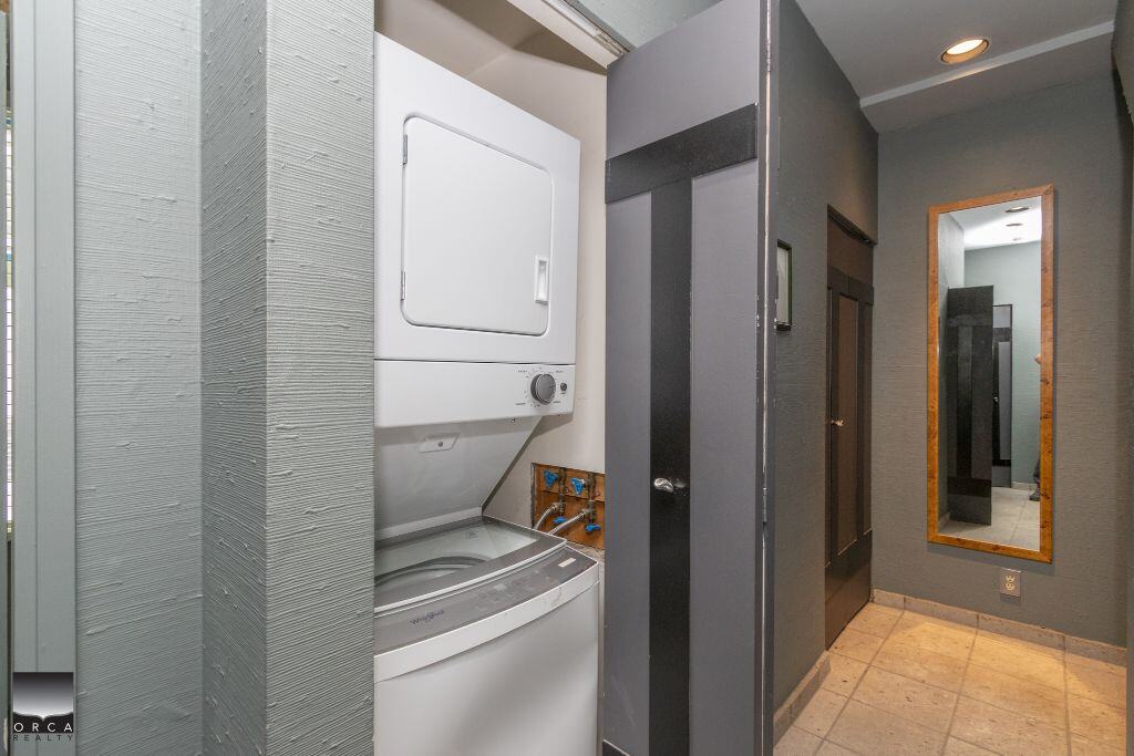 Washer and dryer in a modern laundry room at Orca Realty Inc., Vancouver property, featuring efficient appliances and contemporary interior design for easy home living.