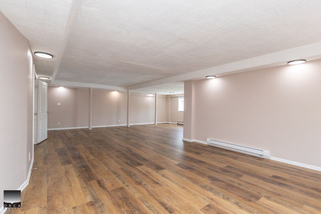 Spacious basement with hardwood flooring and neutral walls, perfect for rental or family living in Vancouver Island, BC.