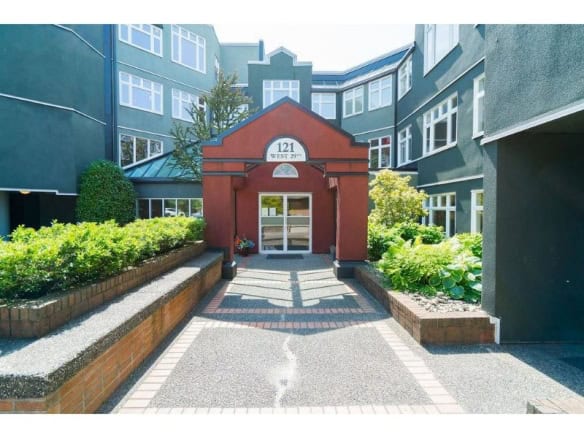 Bright entrance of modern multi-family residential building with landscaped garden and brick accents in Vancouver, BC, showcasing professional property management by Orca Realty Inc.