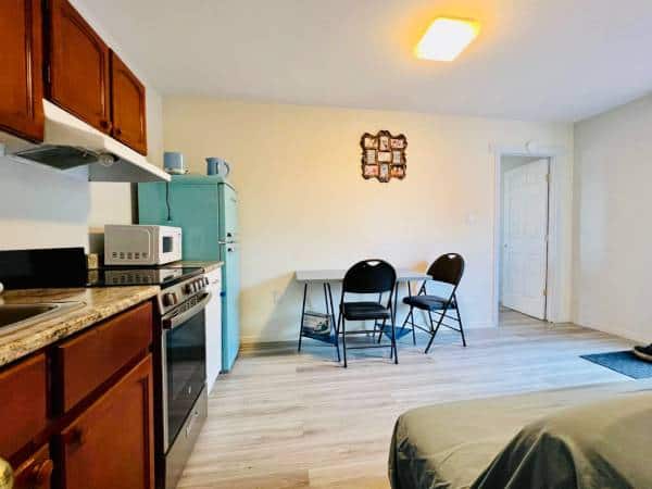 Cozy kitchen and dining area in a Vancouver apartment listing on Orca Realty Inc. showing a compact, functional space with wooden cabinets, a retro fridge, and a small dining table for efficient living.