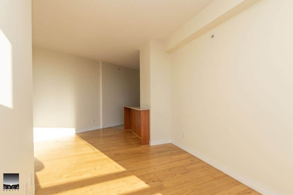 Bright, unfurnished living space with hardwood floors and natural sunlight in a modern Vancouver condo. Excellent location and open layout ideal for homebuyers and renters.