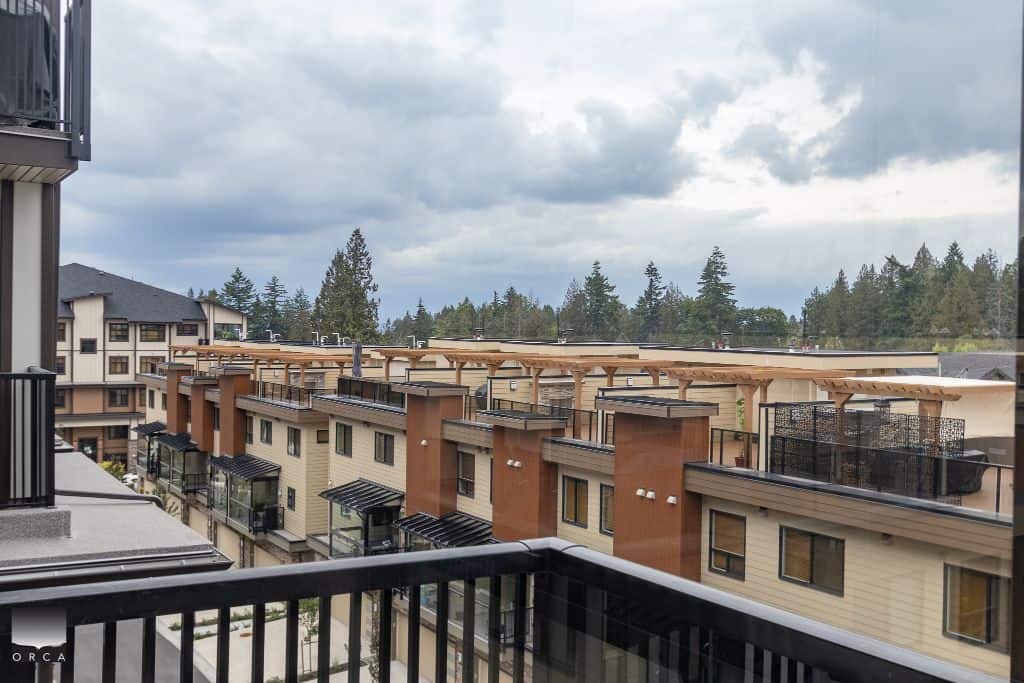 Modern multi-family residential buildings with rooftop solar panels and balconies in a scenic suburban neighbourhood in Vancouver, BC.
