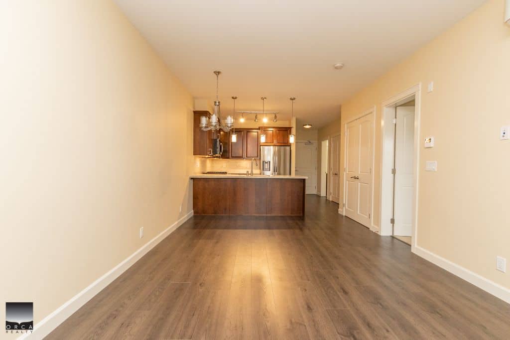 Spacious open-concept living area and modern kitchen in a Vancouver home listed by Orca Realty Inc. for real estate services in BC.