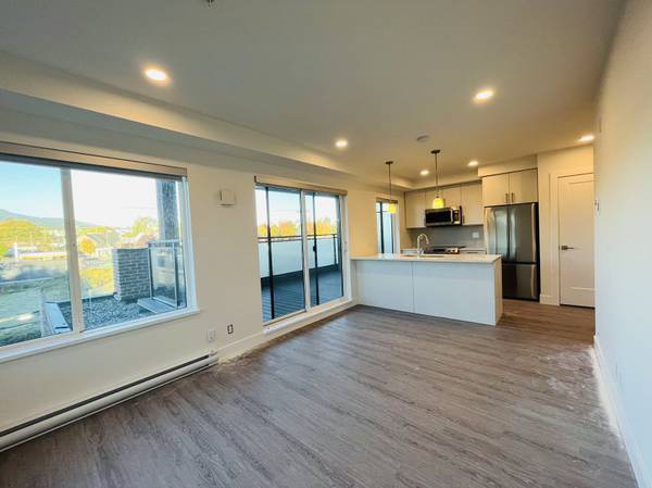 Bright, modern rental apartment interior with large windows, kitchen island, stainless steel appliances, and open-concept living space in Vancouver, BC.