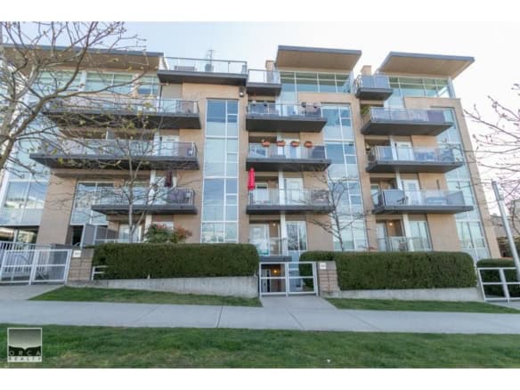 Modern multi-family apartment building with multiple balconies and large glass windows in a contemporary architectural style in Vancouver, BC.