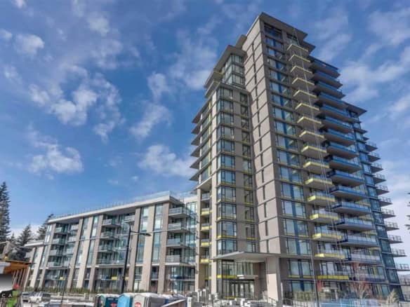 Contemporary high-rise condominium building with modern glass architecture, balconies, and urban surroundings in Vancouver, BC. Perfect for those seeking luxury waterfront properties and real estate investment opportunities.