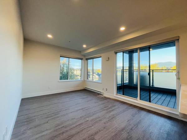 Bright, modern living room with large windows and balcony, showcasing spacious interior and city views in Vancouver, BC. Perfect for luxury homebuyers seeking contemporary condos.