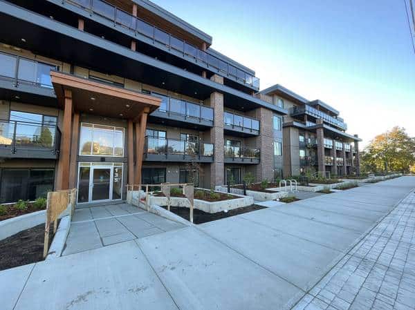 Contemporary apartment building exterior in Vancouver with modern architecture, landscaped walkways, and accessible ramps, showcasing Orca Realty Inc.'s property management expertise.