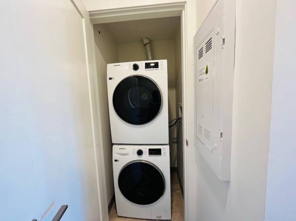 Stacked front-loading washer and dryer in a small laundry closet, showcasing efficient use of space in a modern home. Ideal for homeowners looking for practical laundry solutions with quality appliances.