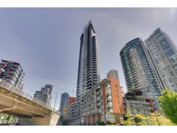 Modern high-rise downtown Vancouver skyscraper with glass exterior and surrounding residential buildings.