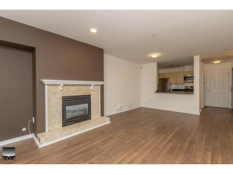 Spacious living room with modern fireplace, open floor plan, and hardwood flooring, perfect for family living and entertaining in Vancouver's real estate market.