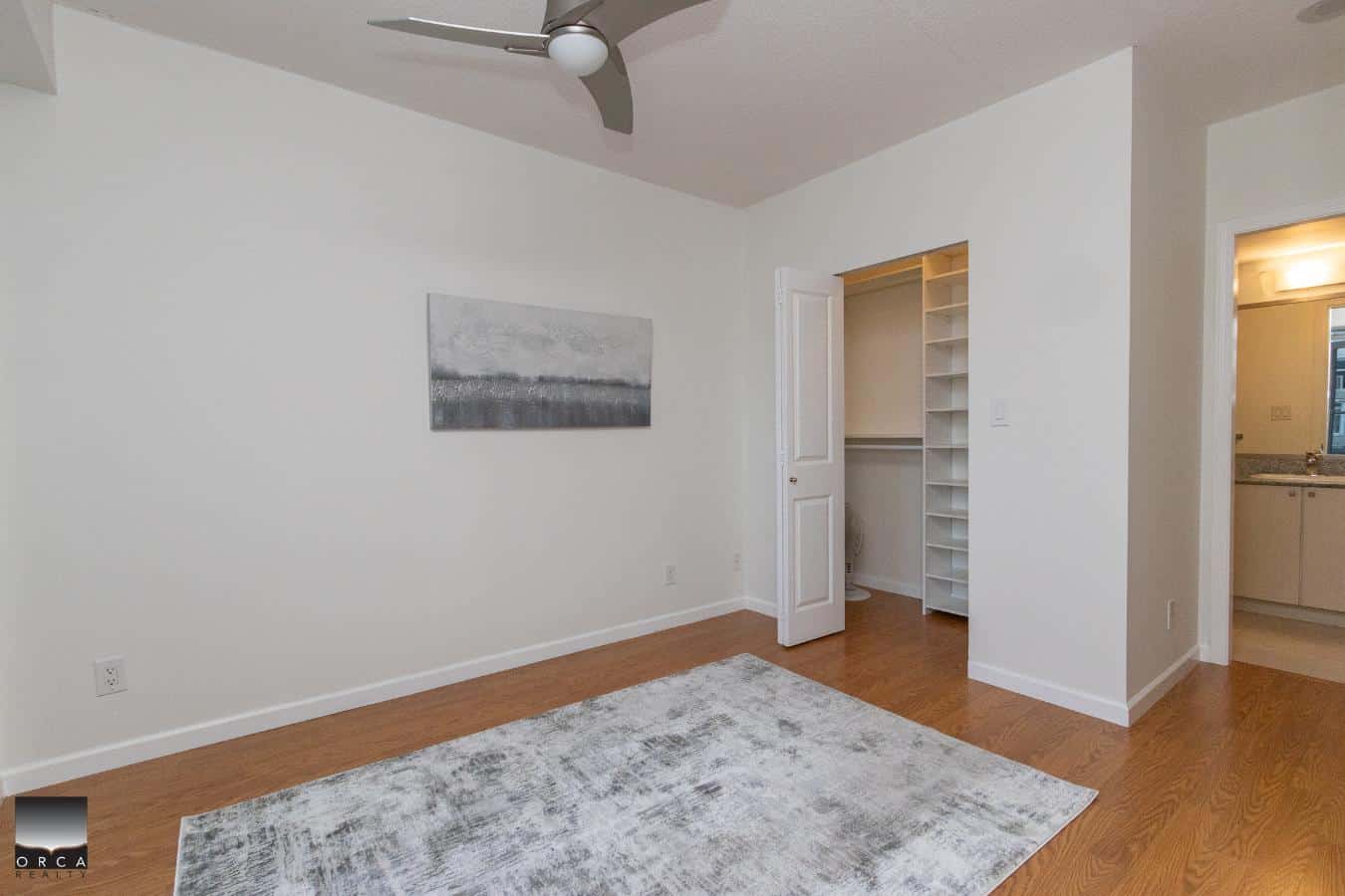 Bright and spacious bedroom with modern finishes, hardwood flooring, and ample closet space, perfect for Vancouver Island real estate buyers seeking comfort and style.