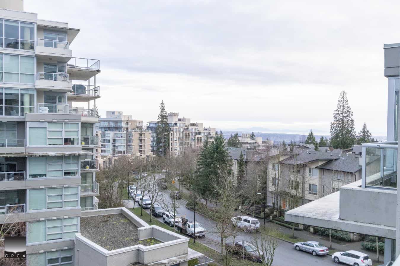 Modern residential apartment building exterior with balconies and large windows in a cityscape.