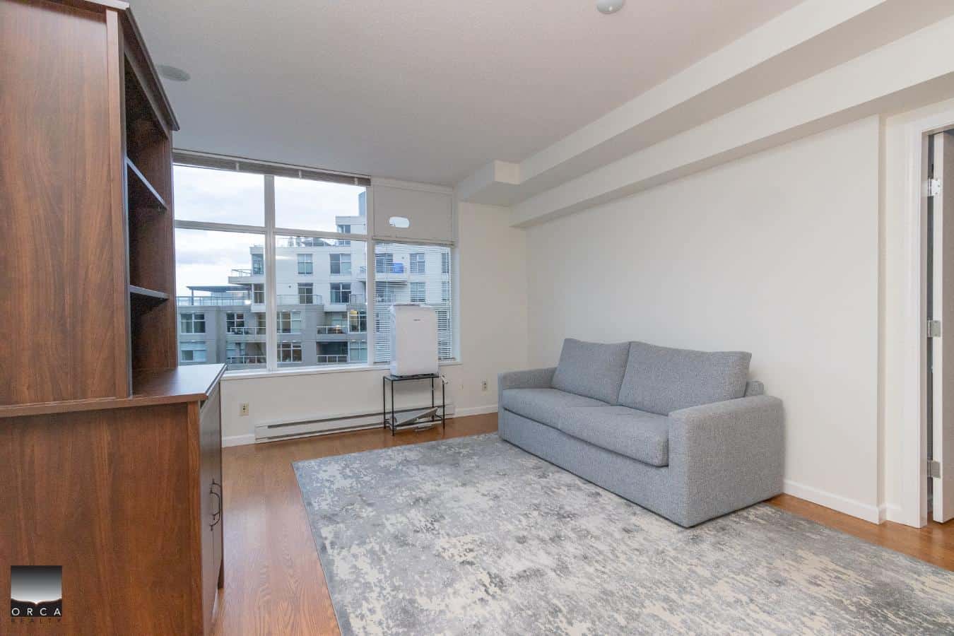 Cozy modern living room with large windows, neutral-toned furniture, and hardwood floors, ideal for Vancouver urban homes or condos.