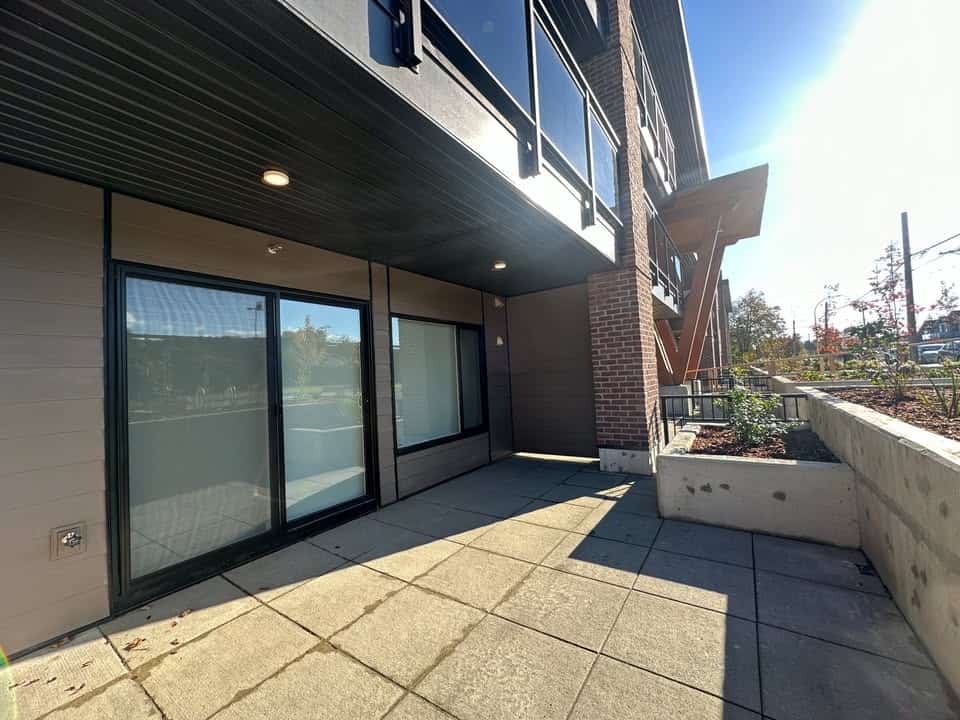 Modern commercial building exterior with patio area, large glass doors, and contemporary architectural design in a Vancouver neighbourhood.